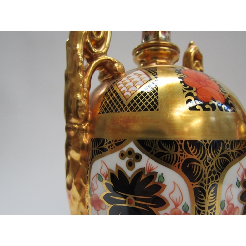 5116 - A pair of Royal Crown Derby Imari pattern urns, ovoid form with fixed knop cover and two high loop h... 