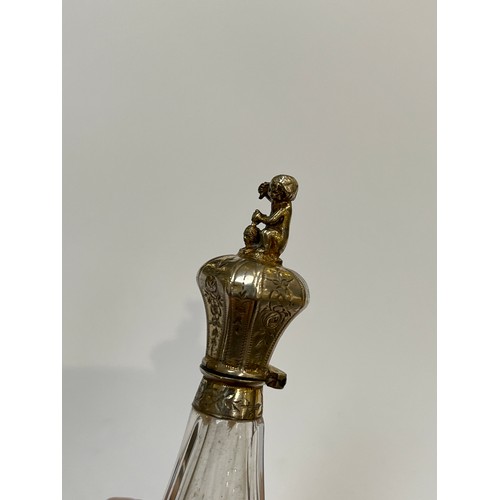 5214 - A continental white metal and cut glass scent bottle of faceted teardrop form, the lid surmounted by... 