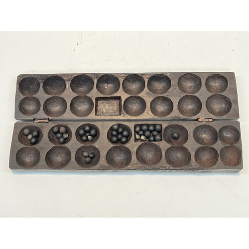 5227 - A carved wood Oware game set, played with small pebbles dipped in sand and earth, East African origi... 