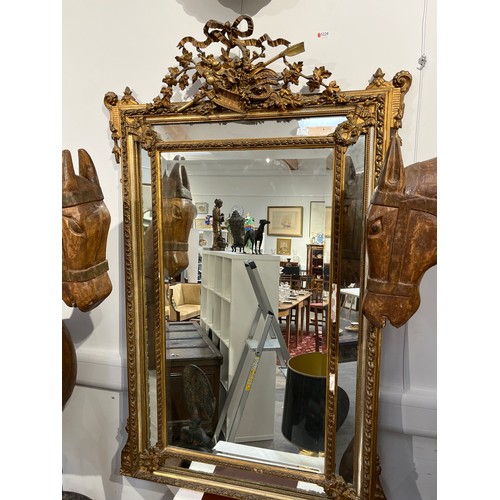 5230 - A 19th Century French gilt wood and gesso wall mirror, ribbon and basket of foliage crest, faceted b... 