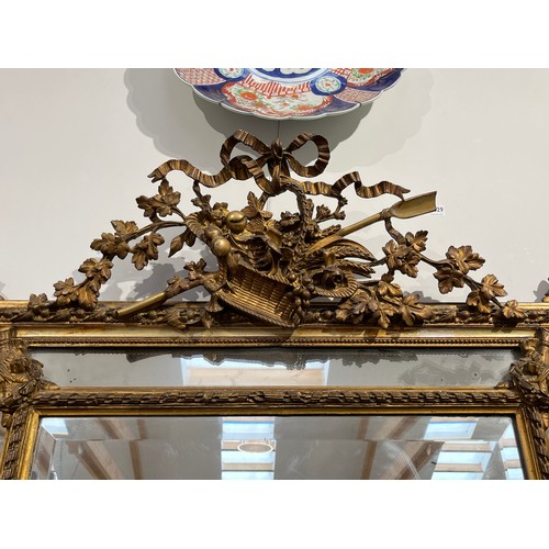 5230 - A 19th Century French gilt wood and gesso wall mirror, ribbon and basket of foliage crest, faceted b... 