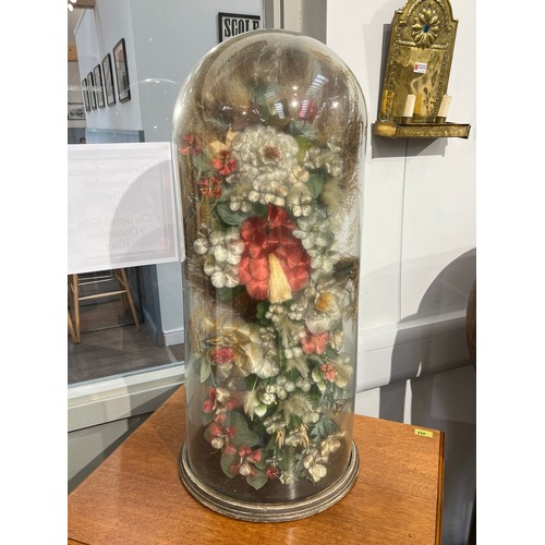 5237 - A tall glass dome housing a display of man-made and natural dried flowers, 81cm tall