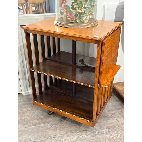 5238 - A late Victorian oak revolving bookshelf the rising bookrest over black ceramic castors, 89cm tall