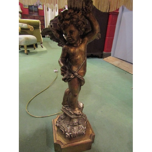 4010 - A gilt winged putti table lamp standing on a decorative plinth (shade included), 76cm tall without s... 