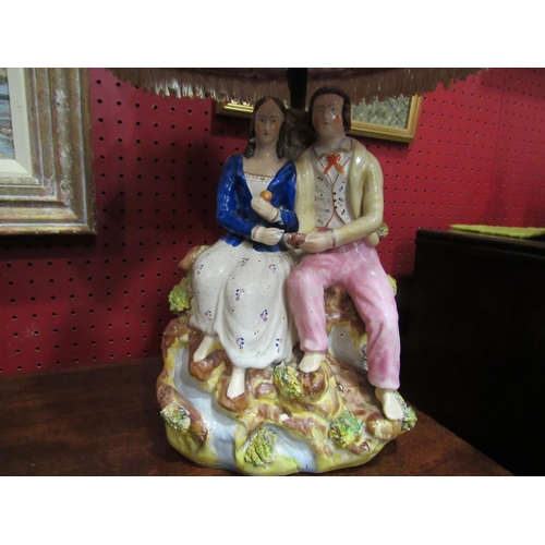 4026 - A Staffordshire table lamp in the form of a courting couple together with a silk pleated and tassell... 