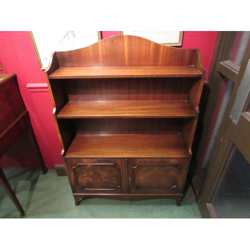 4083 - A Bevan Funnell Georgian style mahogany waterfall bookshelf, the two door cupboard with key over out... 