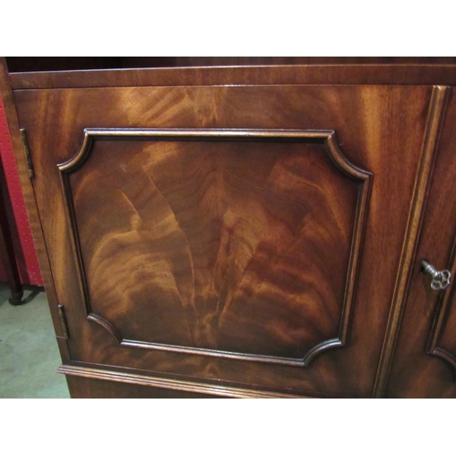 4083 - A Bevan Funnell Georgian style mahogany waterfall bookshelf, the two door cupboard with key over out... 