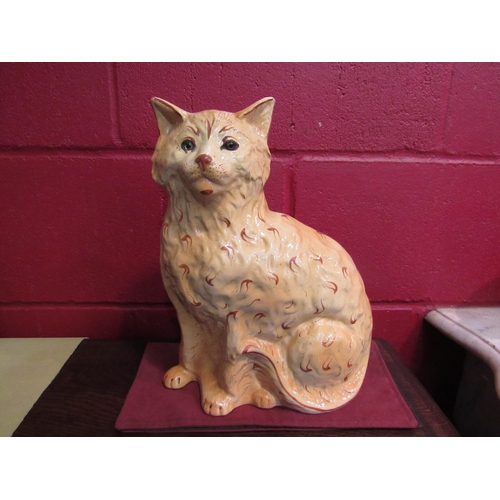 4137 - A large hollow moulded pottery seated cat with glass eyes, 32cm high