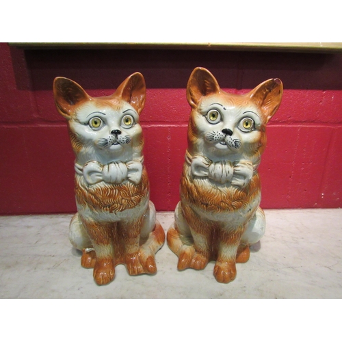 4142 - A pair of large Staffordshire pottery cats with glass eyes, 31cm high