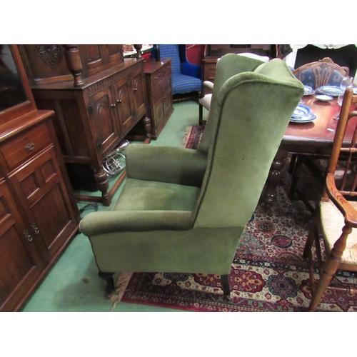 4166 - A 19th Century wing back fire side armchair the scroll arms over cabriole fore legs on ceramic casto... 