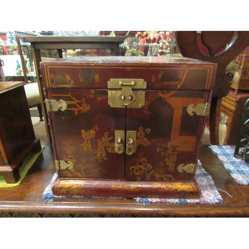 4184 - A Chinese gilt and red lacquered curiosity/collectable cabinet with lift-up lid, two doors opening t... 