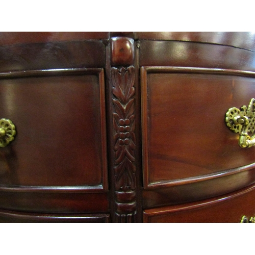 4211 - A Georgian style mahogany bow front chest, the sun ray veneered top over twelve drawers and carved l... 