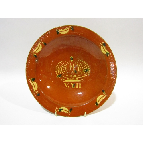 4258 - A slipware dish with crown and leaf decoration, 27cm diameter