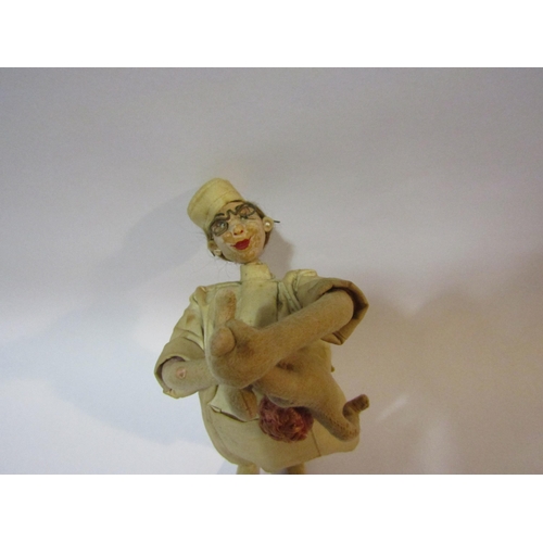 4259 - An unusual mid 20th Century doll in the form of a midwife holding a baby by the feet, 24cm high