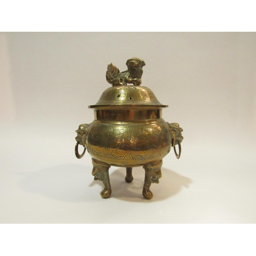 4285 - A Chinese brass censer with cover on tripod mask design feet, twin mask detail to body holding ring ... 