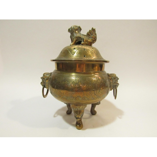 4285 - A Chinese brass censer with cover on tripod mask design feet, twin mask detail to body holding ring ... 