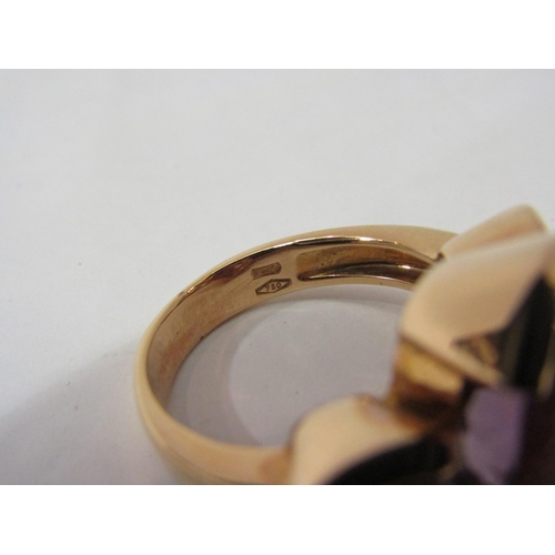 4407 - A gold ring stamped 750 with central oval amethyst flanked by round amethysts, size P, 11.9g     (E)... 