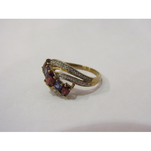 4428 - A gold ring set with tanzanite, garnet and diamond chips, marked 375, size P/Q, 2.8g  (C)