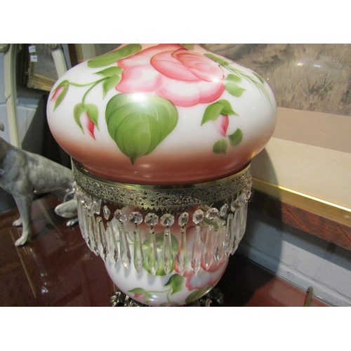 1050 - A double opaque bulbous form table lamp, hand-painted foliate design, glass drops and chimney, flare... 