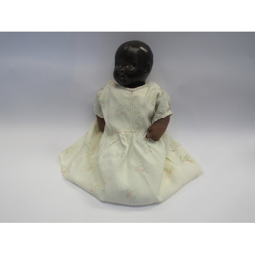 5116 - An English made black baby doll with composition head and cloth body, 39cm tall