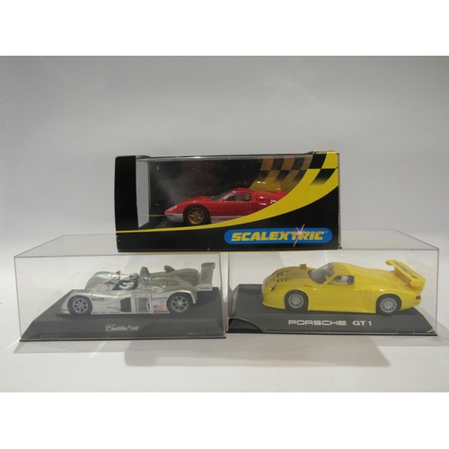 5220 - Three Perspex cased Scalextric slot racing cars to include Porsche GT1 (crack to case), C2424 Ford G... 