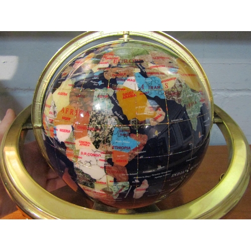 1037 - A World globe inlaid with various stones and shell on brass stand