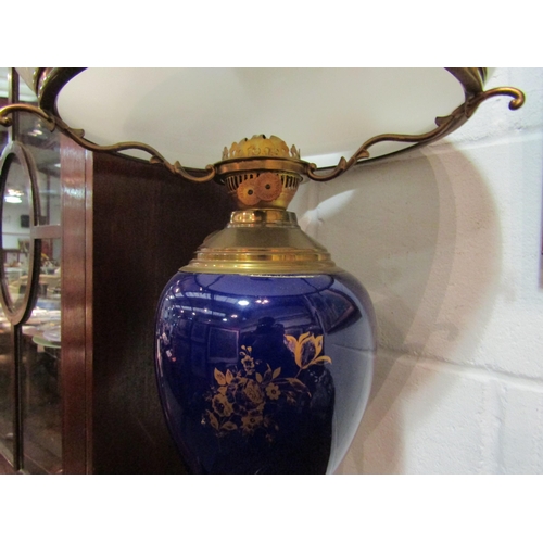 1055 - A 20th Century oil lamp with bulbous blue body, gilt decoration, large white opaque shade with Duple... 