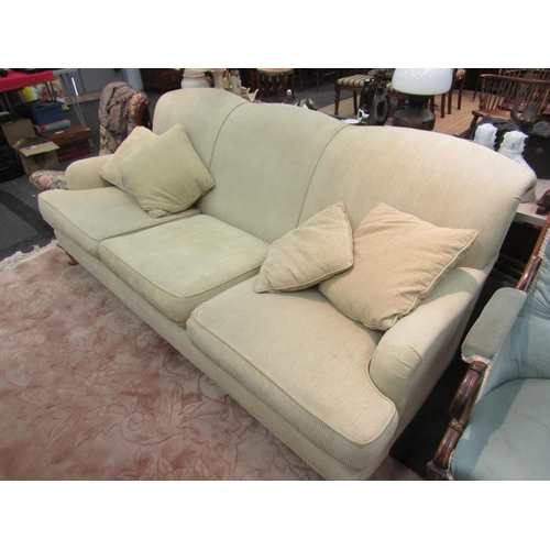 1174 - A three seater sofa on castors with matching cushions, seat cushion a/f