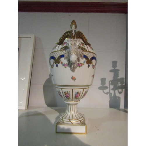 1399 - A Dresden bone china urn with ram head handles, floral spray decoration, gilt embellishment and pier... 