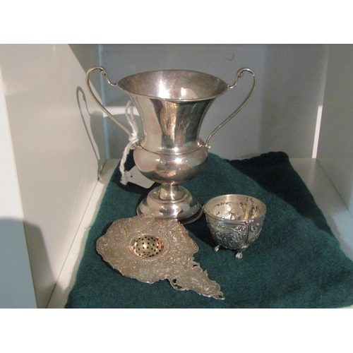 1405 - A silver trophy and an import silver ornate tea strainer on tripod footed bowl (2)