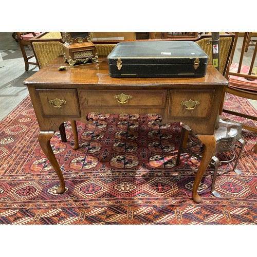 4123 - A walnut lowboy with feather cross banded decoration the three frieze drawers over a shaped apron on... 