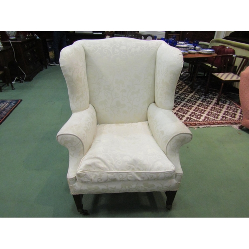 4215 - A George III mahogany wingback fireside armchair with embossed animal upholstery over square taperin... 