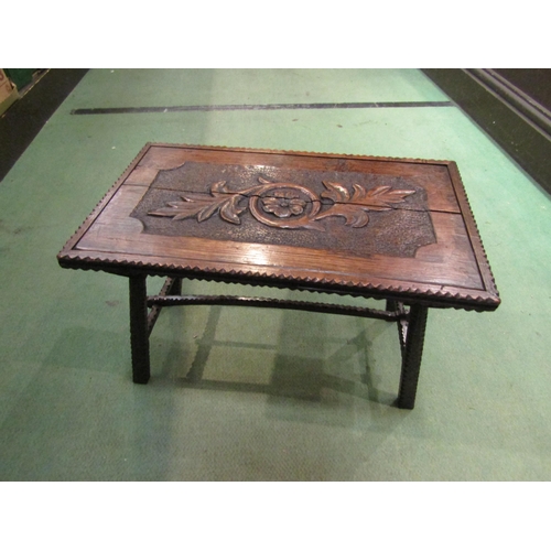 4251 - An Arts & Crafts oak stool with chip carved and figural leaf decoration on outswept legs and arched ... 