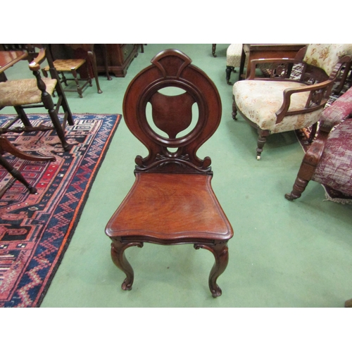 4258 - Circa 1840 a mahogany hall chair, the shield shape back rest over a serpentine front seat on carved ... 