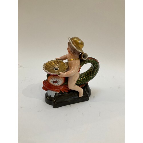 4286 - An unusual late 18th / early 19th Century figural chamber stick as a putto in a hat seated astride a... 