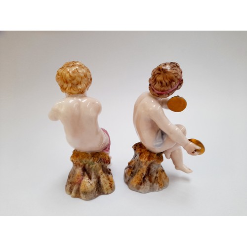 4296 - A Royal Worcester figure of a putto playing a horn. Hand a/f. A matching cymbal-playing putto, cymba... 