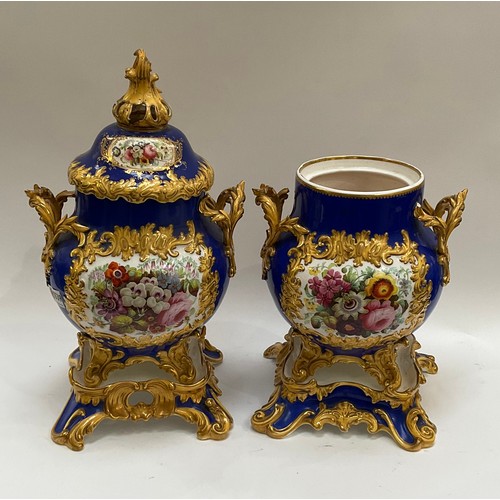 4170 - A pair of Rockingham porcelain lidded urns, blue ground with floral panels, enriched with gilt, heav... 