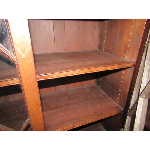 4049 - A Victorian mahogany astragal glazed two door bookcase with height adjustable shelves over ogee brac... 