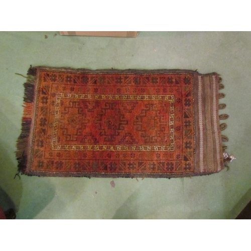 4219 - An Eastern saddle bag, 110cm x 64cm, and a red ground rug with multiple patterned borders, 128cm x 7... 