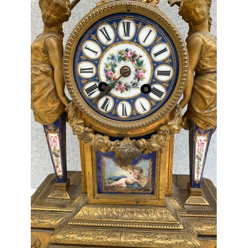 7002 - A late 19th Century French figural ormolu mantel clock, Sevres style face and panels, surmounted by ... 