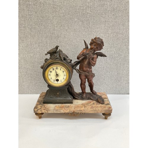 7006 - An Art Deco spelter and marble mantel clock, winged putto “Flute Enchanter” beside waisted clock, ra... 