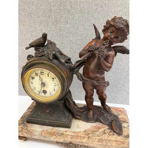 7006 - An Art Deco spelter and marble mantel clock, winged putto “Flute Enchanter” beside waisted clock, ra... 