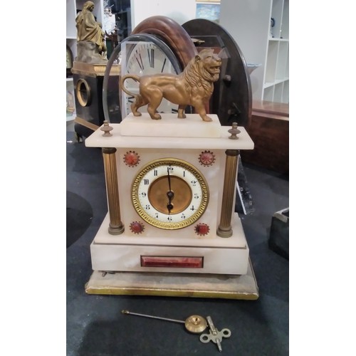 7292 - Two alabaster mantel clocks, one surmounted by lion, one with face damaged, both with pendulums