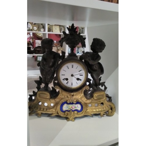 7300 - A 19th Century French spelter and ormolu figural clock with painted ceramic panel to base