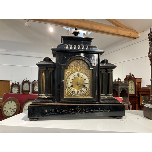 7252 - A circa 1900 ebonised wood mantel clock of architectural form, gilt brass relief surrounding Roman d... 