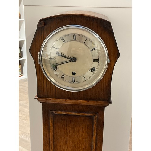 7326 - A 1920s oak cased Grandmother clock with Roman numerated metallic dial, with pendulum