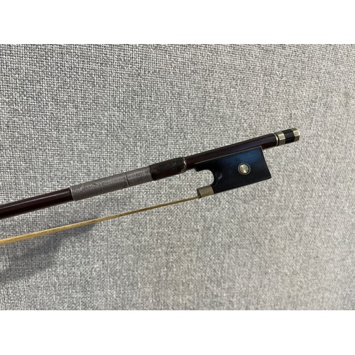 5085 - An early 20th Century violin bow, ebony frog, round stick, mother of pearl inlay and plated metal mo... 