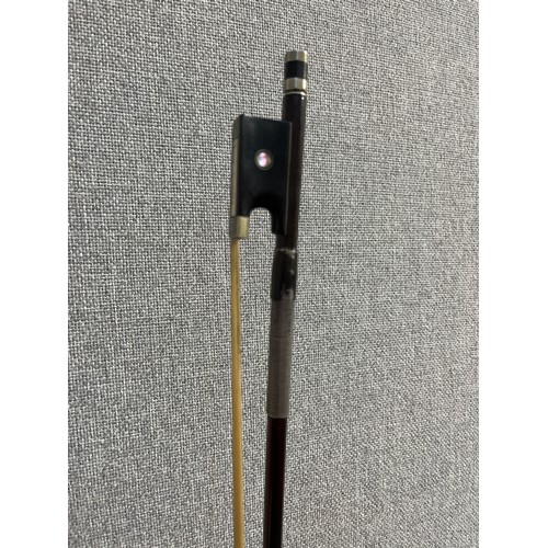 5085 - An early 20th Century violin bow, ebony frog, round stick, mother of pearl inlay and plated metal mo... 