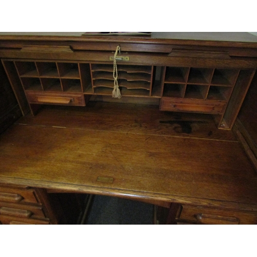 1013 - A Circa 1900 oak roll top desk with key, 119cm high x 125cm wide x 75cm deep