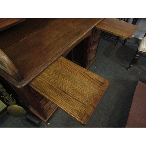 1013 - A Circa 1900 oak roll top desk with key, 119cm high x 125cm wide x 75cm deep